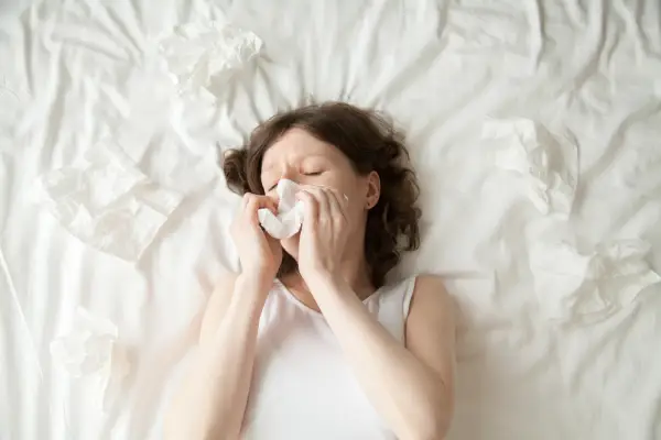 drolimpiuharceaga young woman sneezing into tissue
